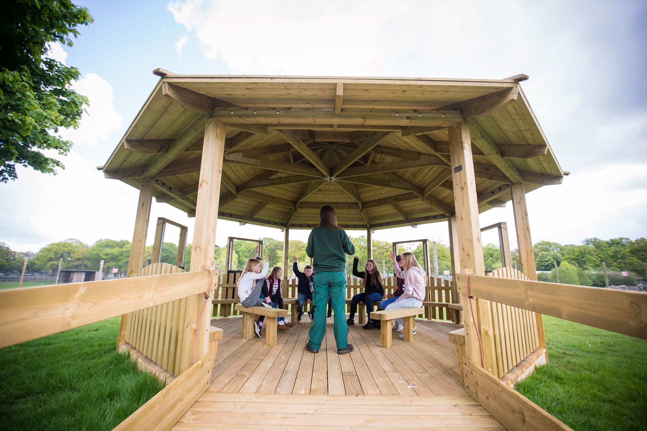 A group of children sit in the Outdoor Classroom at Woburn Safari Park