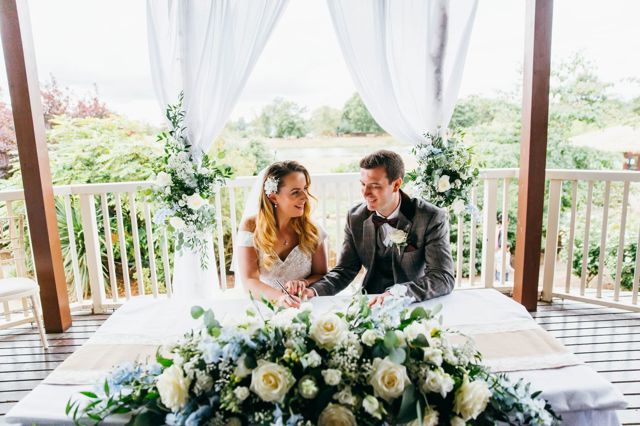 Bride and Groom sign marriage papers on decking on Safari Lodge 